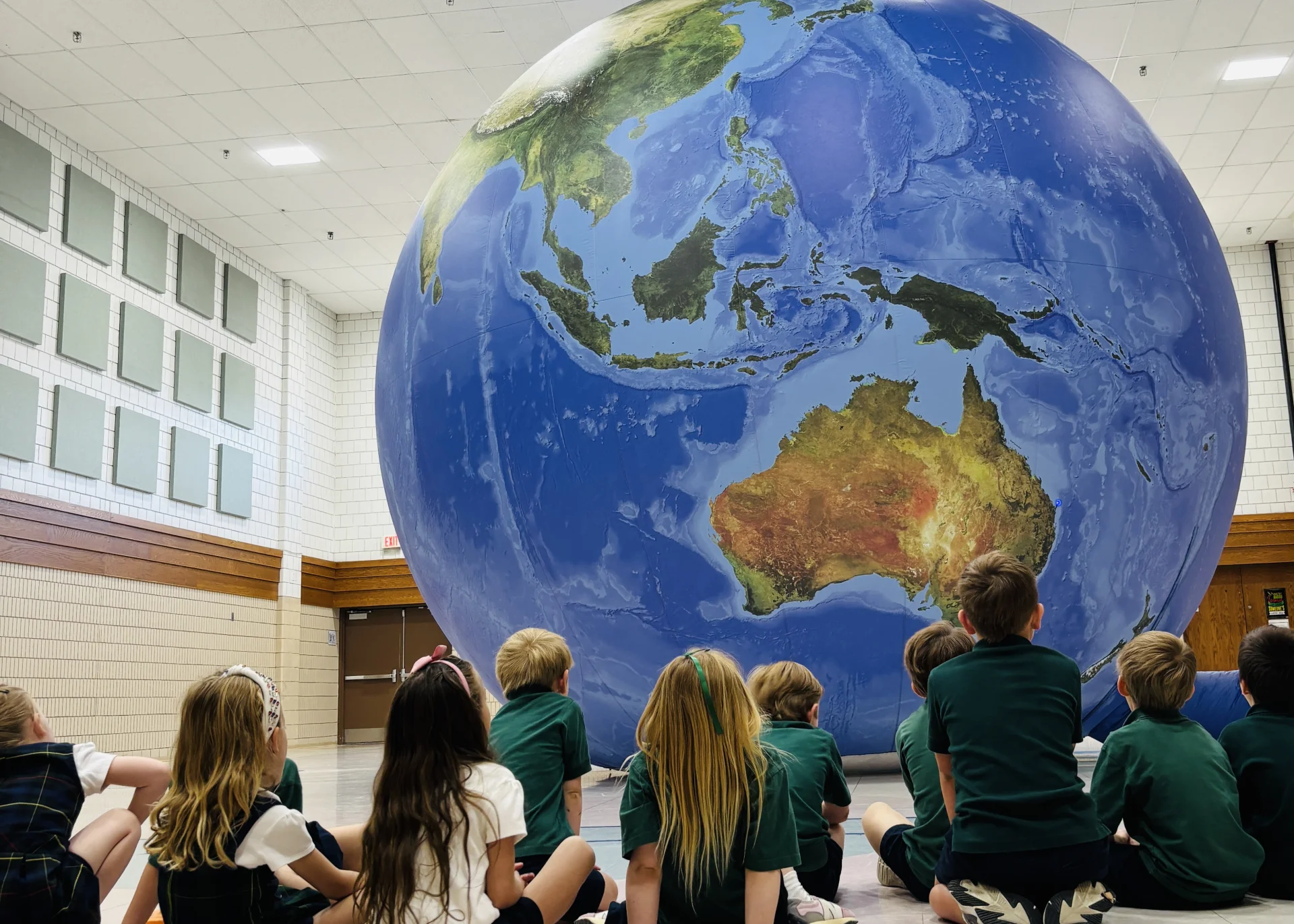group of students looking at globe