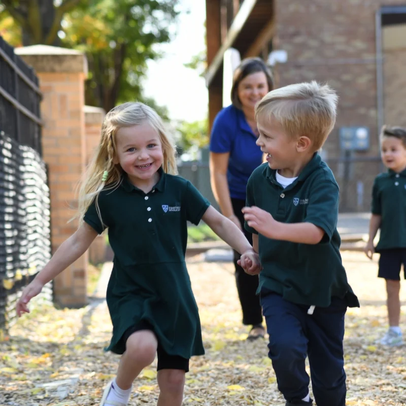 two kids running on playground