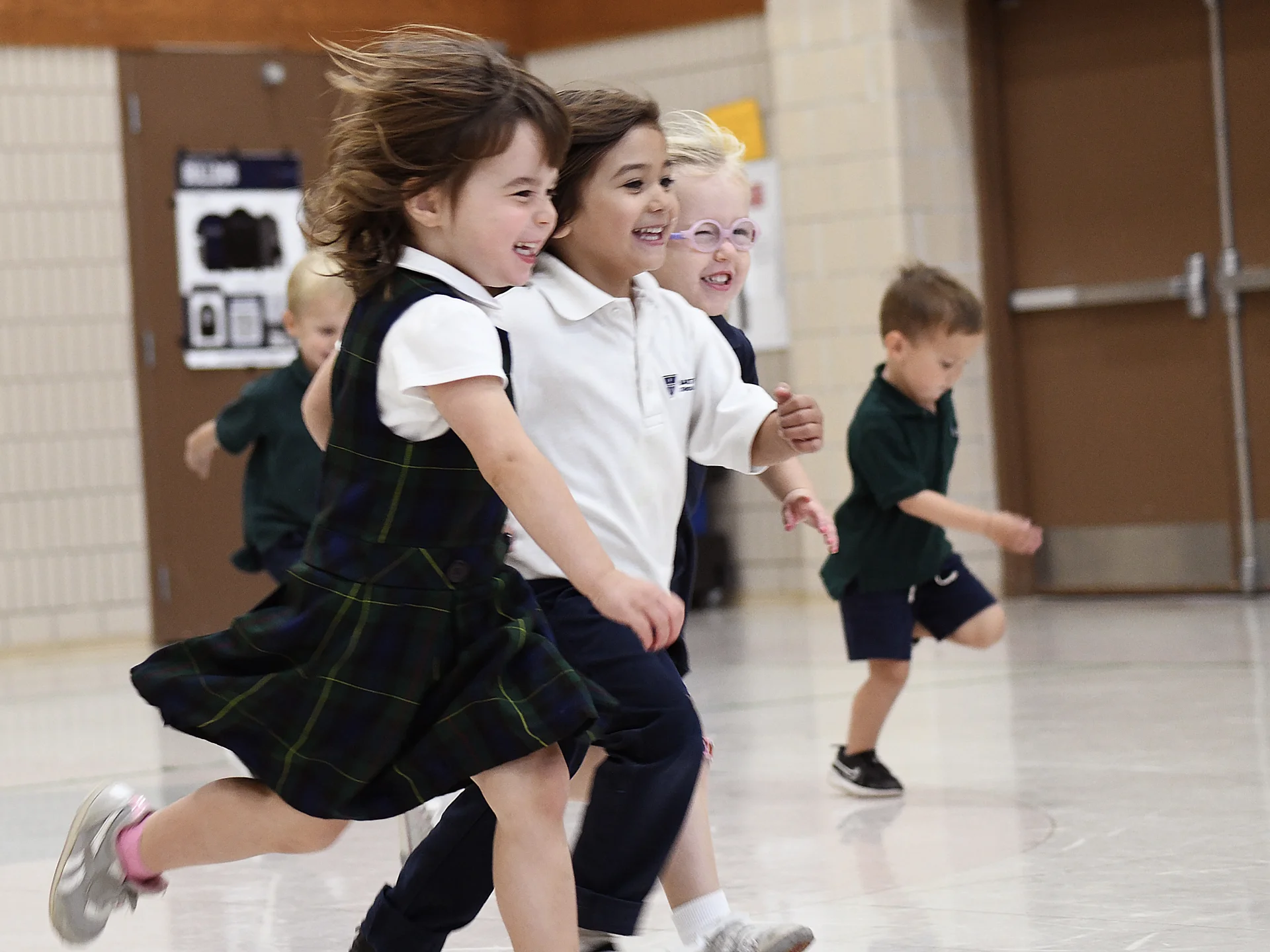 two preschool students running on playground